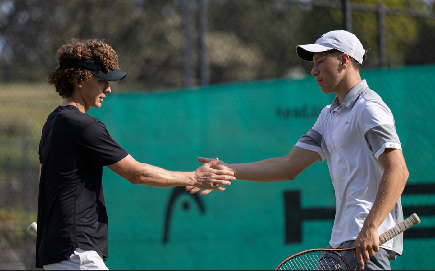 Two players sharing a handshake at the net